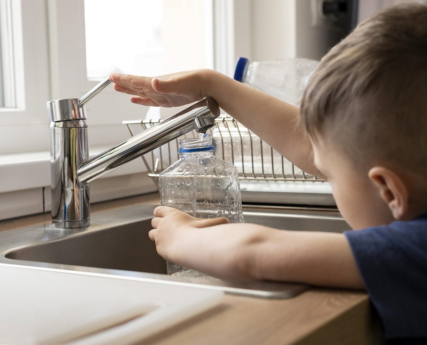 close-up-kid-filling-bottle-with-water.jpg