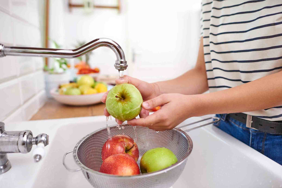a woman washing vegetables with filtered water