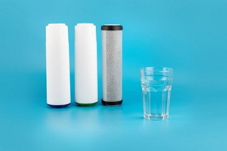 set-three-cartridges-water-filter-with-clear-glass-water-isolated-blue-background.jpg