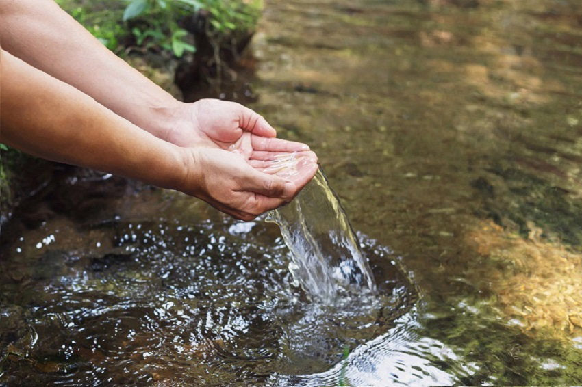 man-s-hand-touching-water-midst-nature.jpg