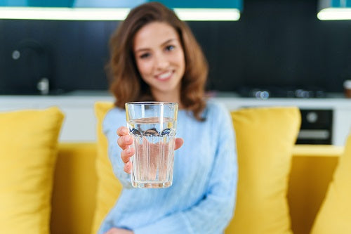 a woman holding a bottle of filtered water