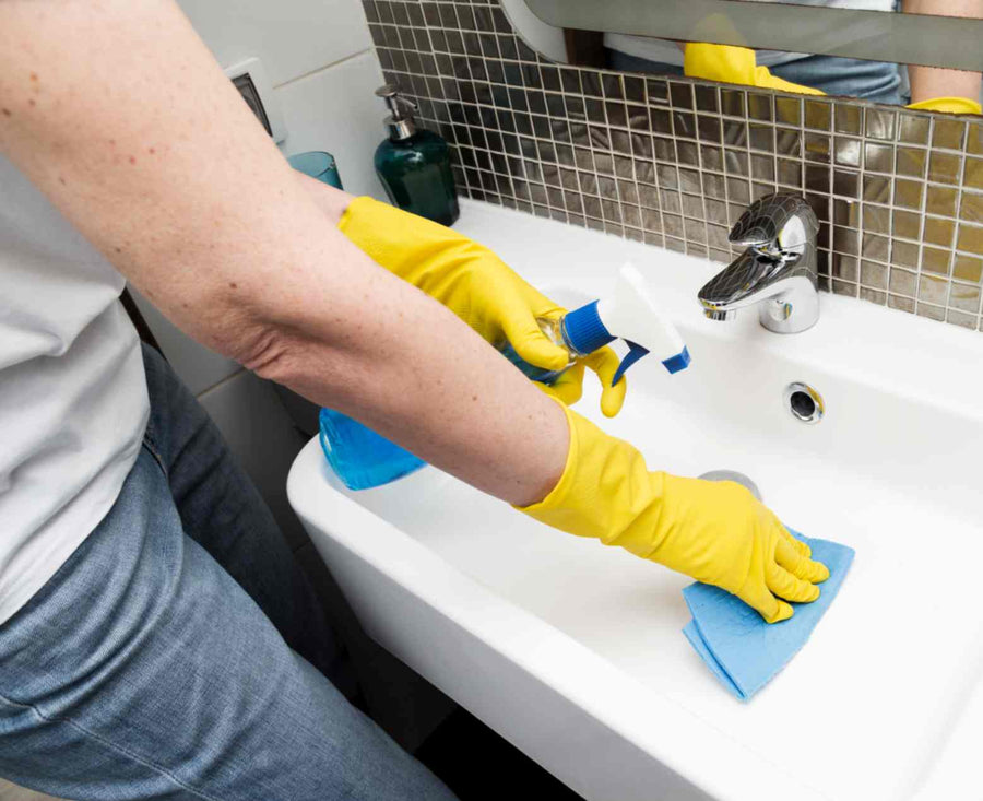 a-woman-cleaning-limescale-buildup-around-a-sink.jpg