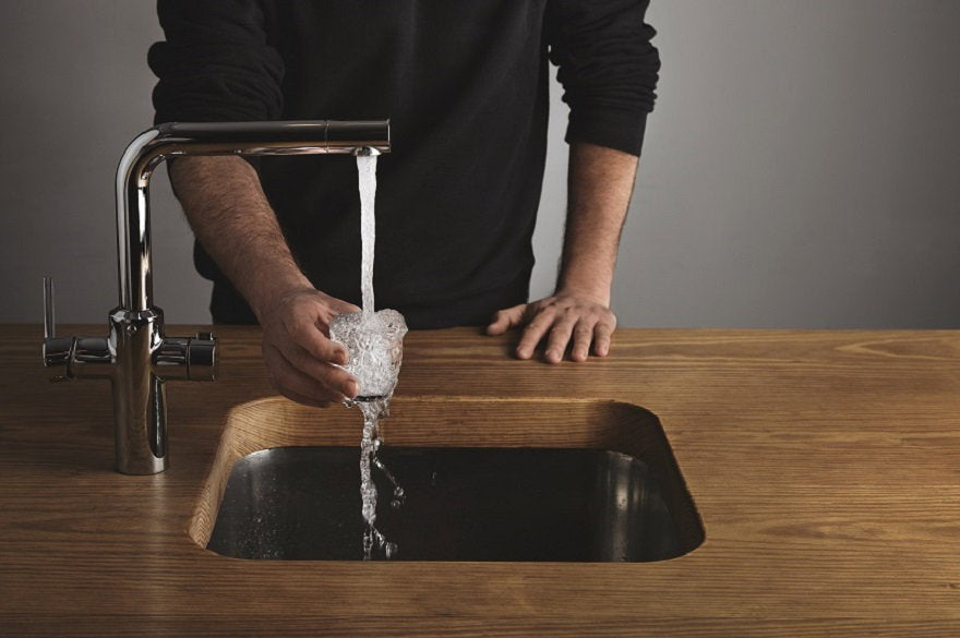 brutal-barista-black-sweatshot-thick-wooden-table-rinses-small-tranparent-glass-with-water-silver-metal-tap-cafe-shop-water-drops-out-glass.jpg