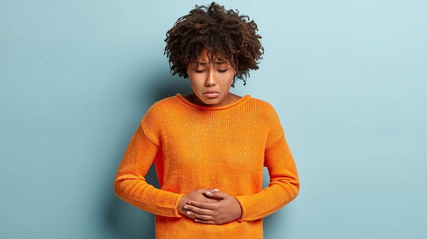 discontent-afro-american-female-suffers-from-abdominal-stomach-pain-touches-belly-with-both-hands-looks-down-wears-orange-jumper-has-menstruation-curly-haircut-models-blue-wall.jpg