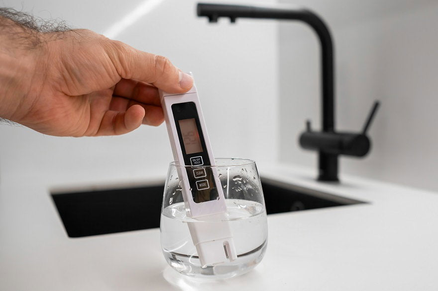 man-hand-immerses-conductometer-beaker-water-check-purity-front-modern-kitchen.jpg
